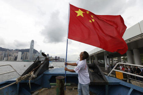 An activist fastens the Chinese flag on a fishing boat before departing for the disputed islands Senkaku in Japan, or Diaoyu in China, in Hong Kong