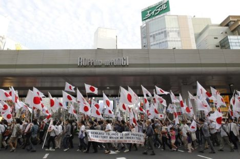 Protesters hold Japanese national flags during an anti-Chinese march in Tokyo